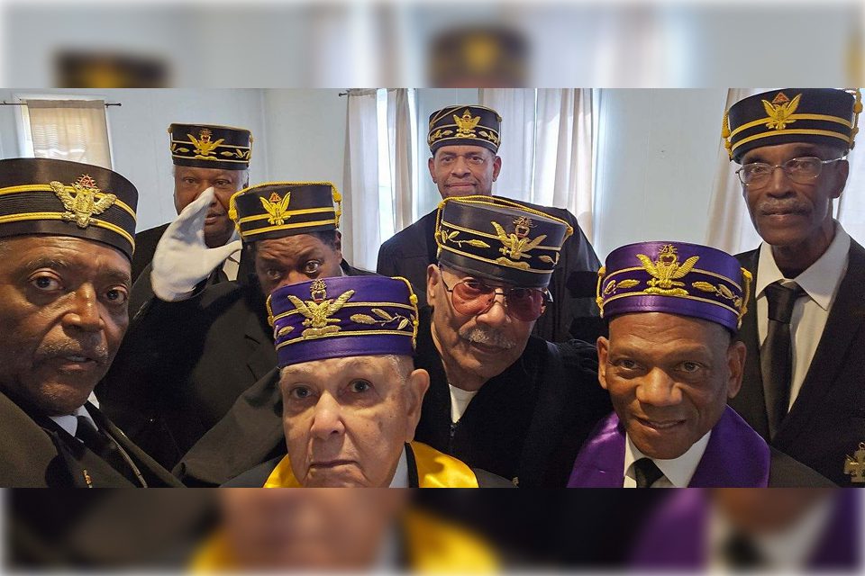 A group of men wearing purple and yellow hats.