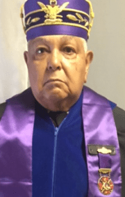 A man in purple and black graduation outfit.