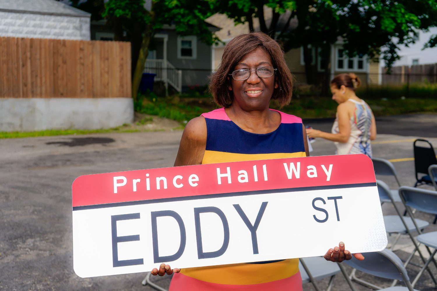 A woman holding up an eddy street sign.