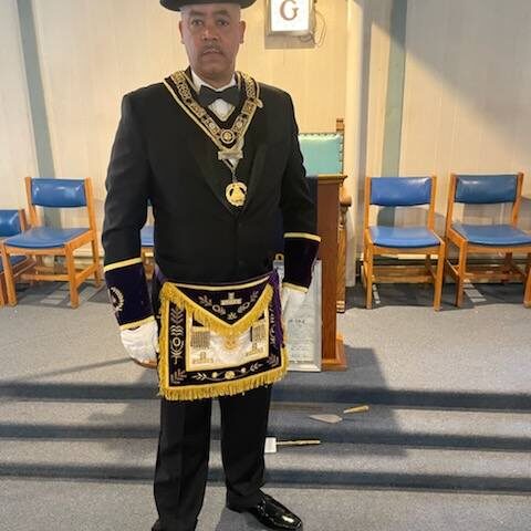 Man in formal attire with ceremonial regalia.
